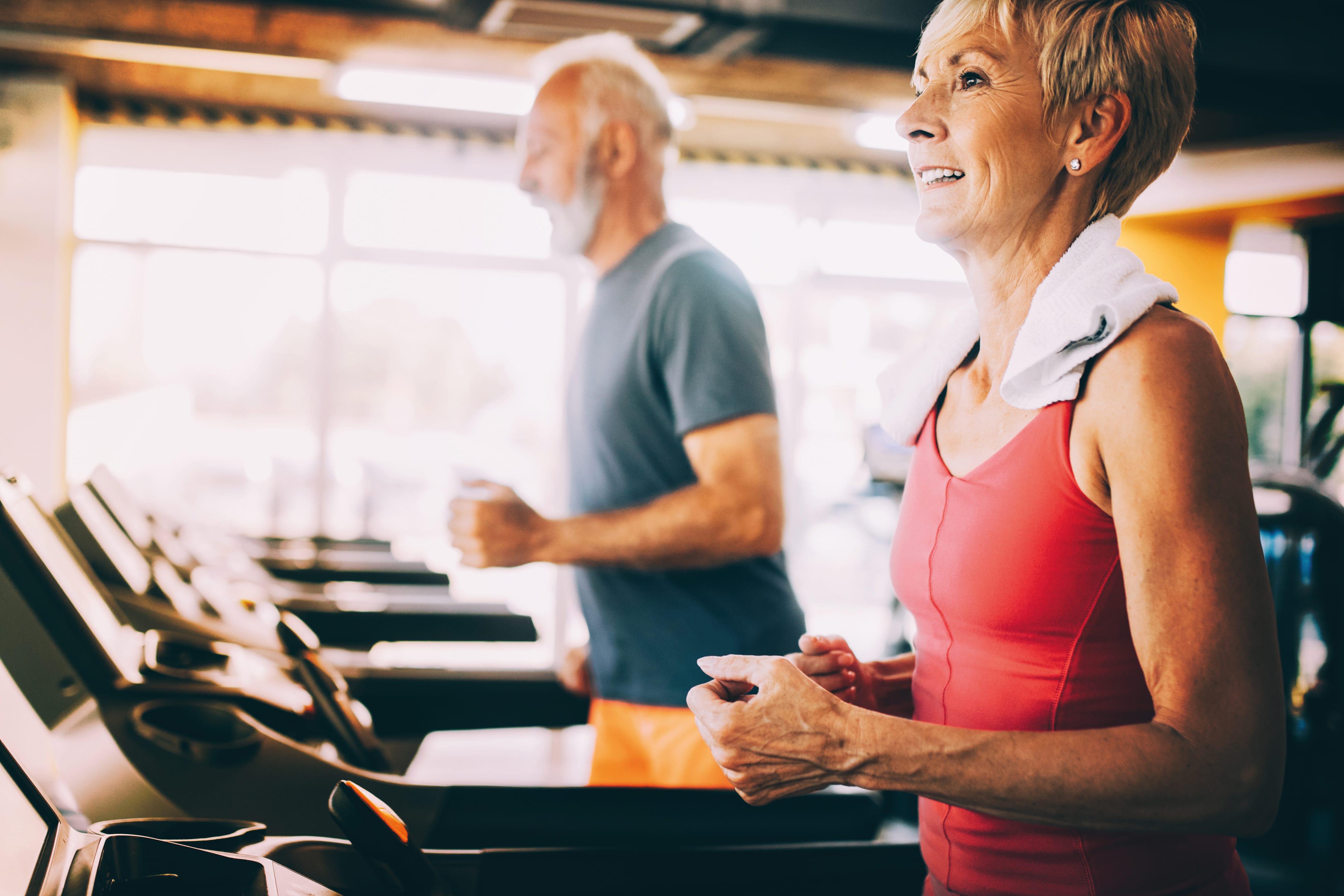 Covid-Sportgruppe_LLSGA Mature people running in machine treadmill at fitness gym club