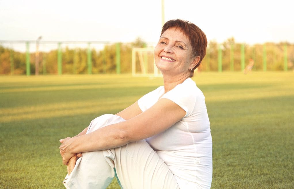 Frau sitzt im Gras
