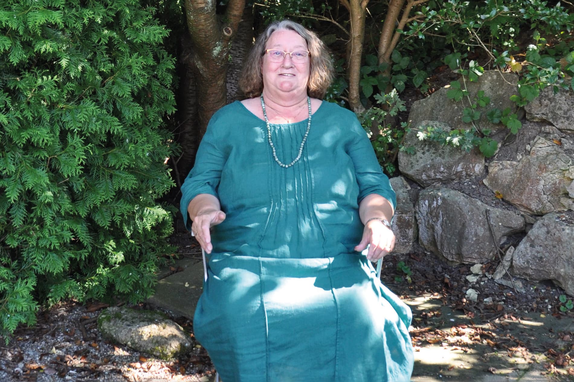 Frau sitz auf einem Stuhl im Garten