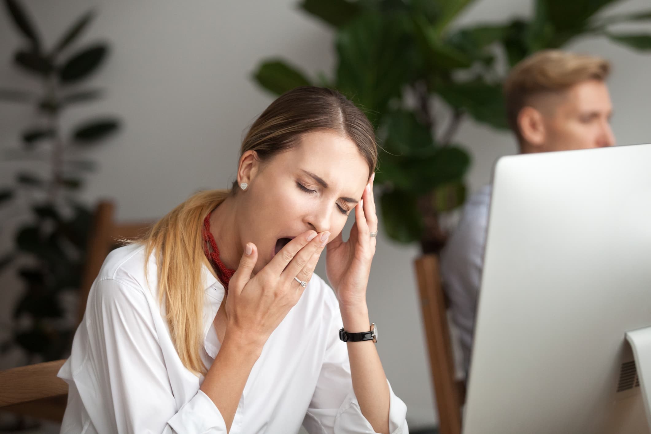 Welttag des Schlafes Eine Frau gähnt am Arbeitsplatz