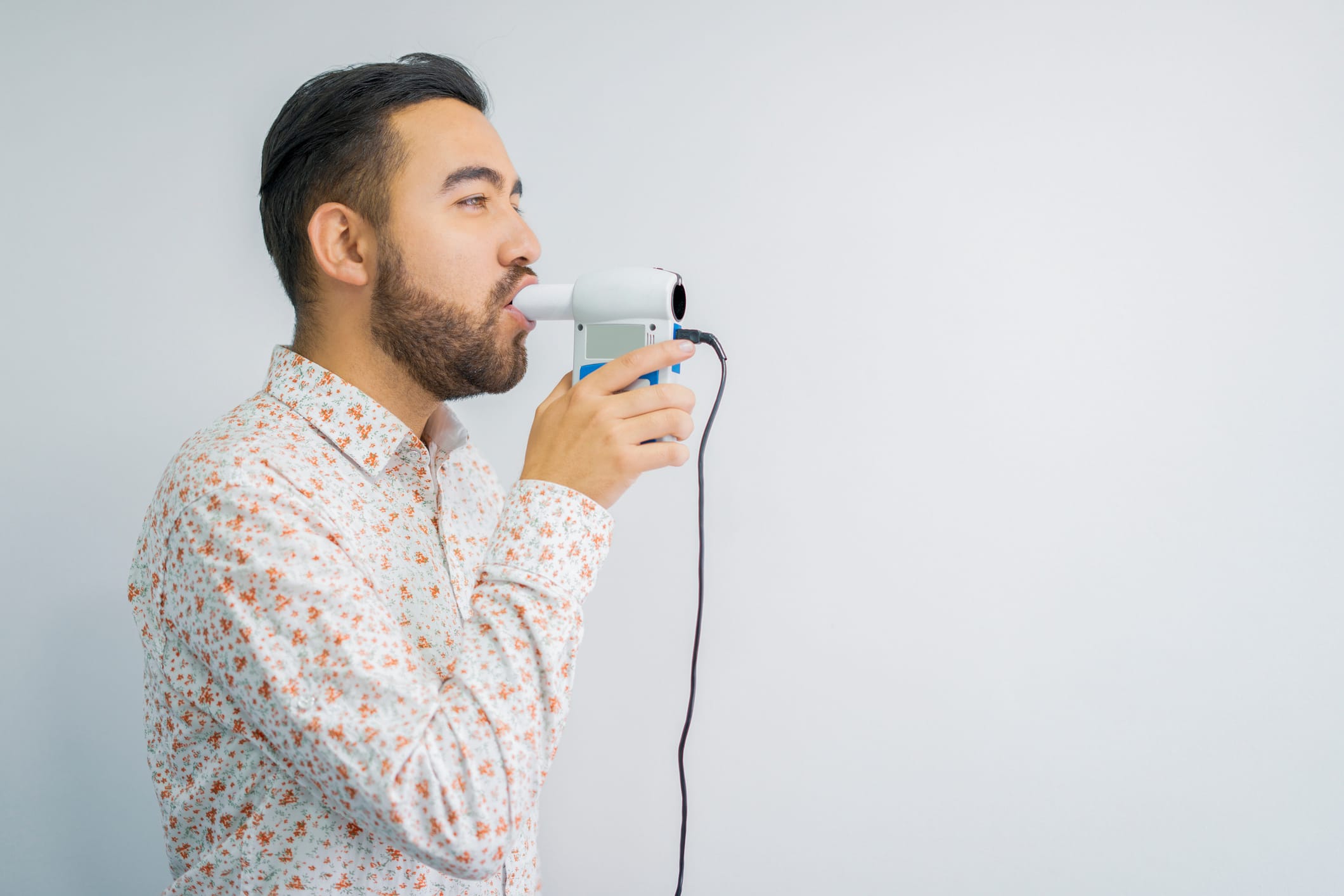 Junger mann bläst in ein Spirometrie-Gerät