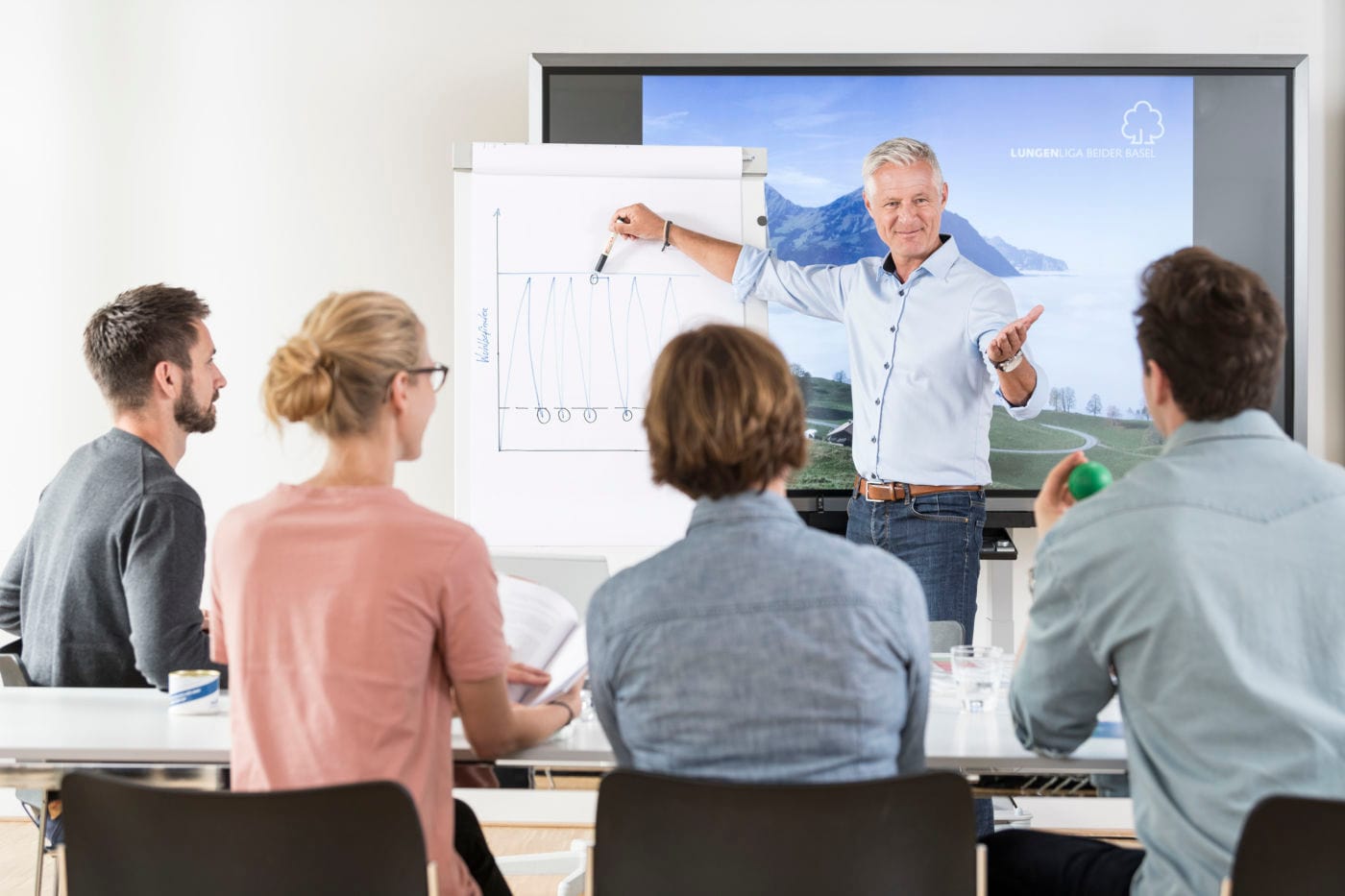 Pulmotion Rauchstopptraining Ein Mann hält ein Referat vor Publikum
